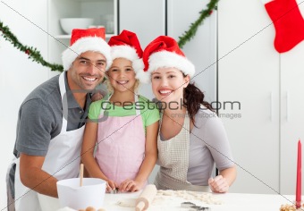 Portrait of a man with wife and daughter cooking Christmas biscu