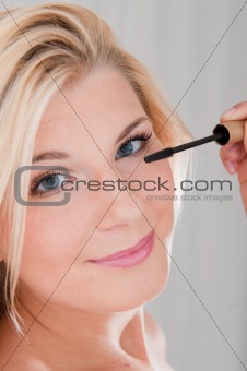 beautiful girl applying black eye mascara