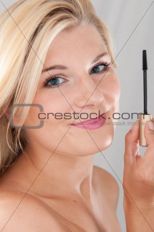 beautiful girl applying black eye mascara