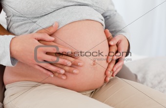 Future parents putting their hands on the belly of the woman