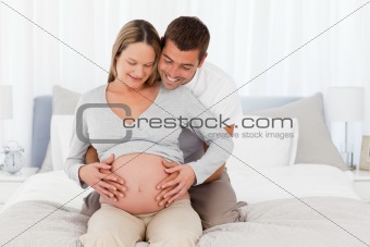 Adorable future mom and dad feeling the belly of the woman