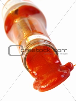 Tasty ketchup flowing out of the bottle isolated on white background 