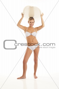 Young woman holding surfboard