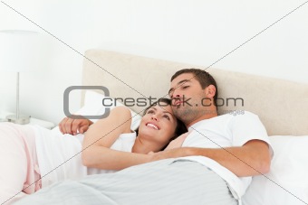 Pensive couple relaxing together lying on the bed