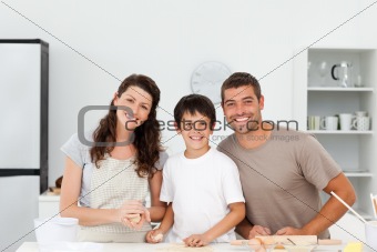 Portrait of a happy family preparing biscuits together