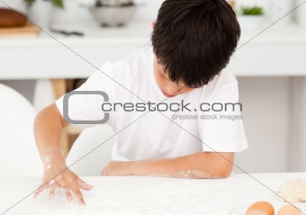 Adorable boy preparing a dough alone