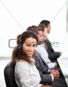 Happy representative with her colleagues working in a call center