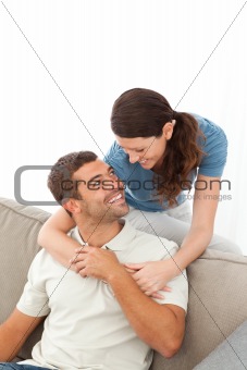 affectionate woman hugging her husband relaxing on the sofa 