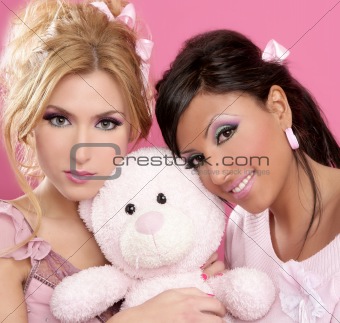 blonde and brunette girls hug a pink teddy bear