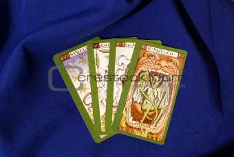 Four tarot cards on blue textile  background