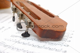 Fingerboard of old guitar under leaf with notes