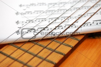 Musician notes under spanish guitar's strings