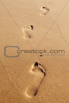 Three human footprints on the beach sand
