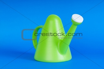 Gardening concept with green watering can on background