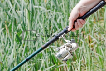 Fisherwoman hand holding a fishing rod