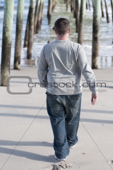 Young Man Walking Under Pier