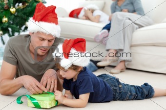 Father and son unwrapping a present