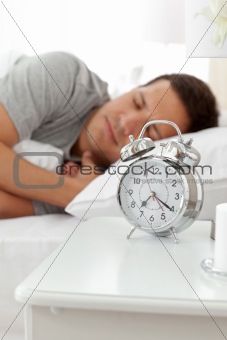 Serene man lying on his bed before being woken up