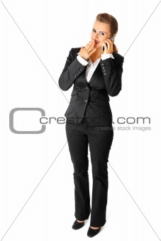 Confused modern business woman talking on mobile phone
