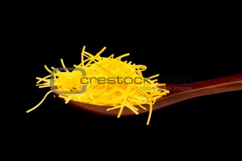 Spaghetti in wooden spoon isolated on black