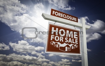 Red Foreclosure Home For Sale Real Estate Sign Over Beautiful Clouds and Blue Sky.