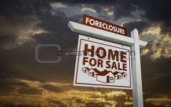 White Foreclosure Home For Sale Real Estate Sign Over Beautiful Clouds and Sunset Sky.
