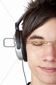 Close-up macro of a male teenager listening to music with headphone