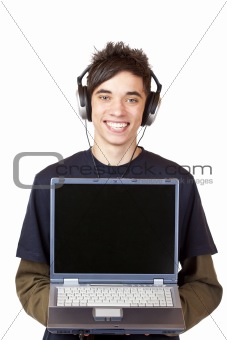 Male Teenager with earphones makes Internet mp3 music download at computer