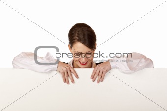 Young happy woman looks down on blank board.