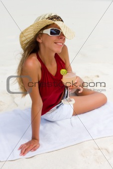 Lady on a tropical beach with cocktail