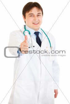 Smiling medical doctor showing thumbs up gesture
