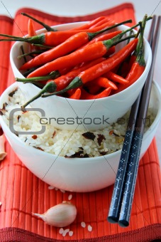 Bowls of uncooked rice and chili peppers