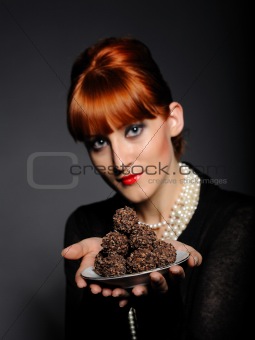 Beautiful elegant fashion woman with chocolate truffle sweets.