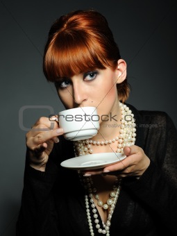 Beautiful aristocratic fashion woman with white pearls drinking 