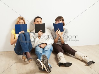 Three amused friends with books