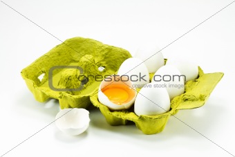 Broken egg in the box on a white background