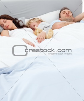 Cute little boy sleeping with his parents 