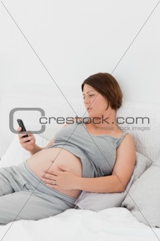 Pregnant woman looking at her mobile