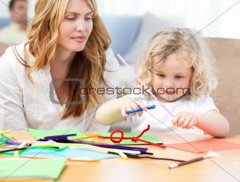 Woman and  her daughter cutting paper