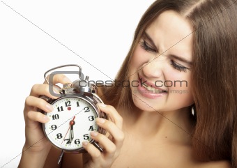 scared girl holding an alarm clock in the hands