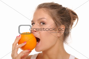Young woman bites an orange