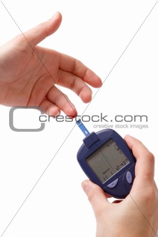 The woman measures glucose level in blood by Glucose Meter