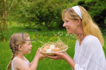 Mother and daughter holding fresh eggs