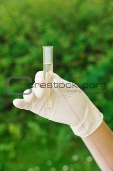 Hand holding test tube with liquid