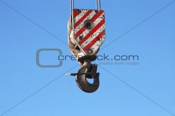 rusty crane hook and steel cables hanging on blue sky