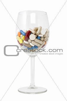 glass of multicolored tablets and capsules