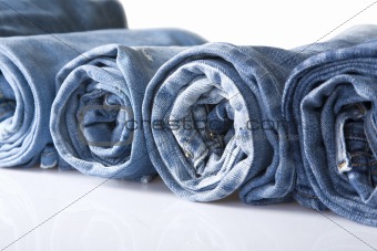 roll blue denim jeans arranged in line