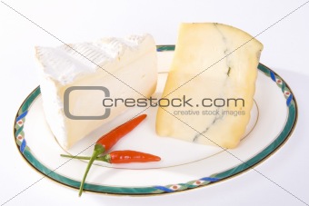 Two cuts of French cheese with red chili peppers