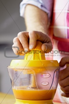 man preparing orange juice at home