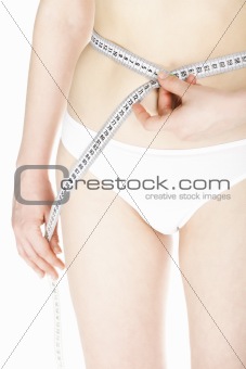 Young caucasian woman measures her body